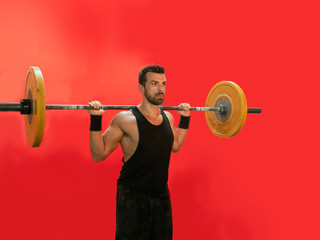 Obraz na płótnie Canvas man lifting a barbell at the crossfit gym