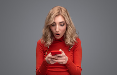 Surprised woman using smartphone