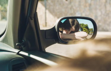 Fototapeta na wymiar Teen girl sitting in the car on a summer afternoon