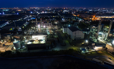 Fototapeta na wymiar Aerial view night light oil terminal is industrial facility for storage of oil and petrochemical. oil manufacturing products ready for transport and business transportation. power electric plant.
