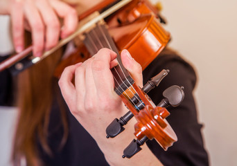 Hands of a young girl playing the violin