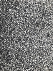 Fototapeta premium Asphalt texture close up. Gray marble chips on asphalt. Stone natural texture of building material for walls and other surfaces. Gray texture of marble chips and asphalt.
