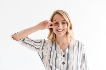 Portrait of beautiful blond woman smiling at camera while showing peace sing