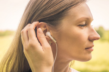 Young woman enjoying music in white headphones outdoors