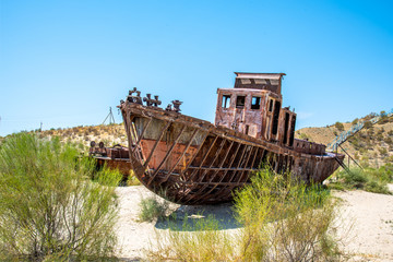 Fototapeta na wymiar A rusting shipwreck in the desert near the former Aral Sea fishing town Moynaq / Muynaq in Uzbekistan / Karakalpakistan