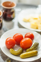 pickled cucumbers and tomatoes on a served table in a white plate