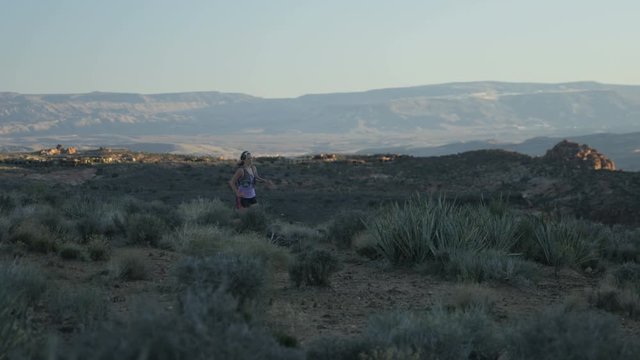 slow motion of girl trail running in desert