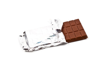 Milk chocolate bar in foil isolated on white.