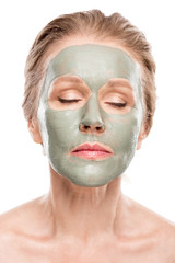mature woman with clay mask and eyes closed Isolated On White