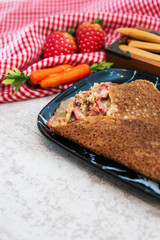 Black wheat and wheat galette topped with cooked ham and emmental cheese