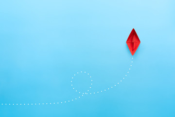 Red paper ship on blue background, business successful journey concept. copy space