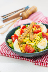 Salad made with cooked pasta, mixed green salads, cherry tomatoes, Mozzarella cheese and smoked ham...