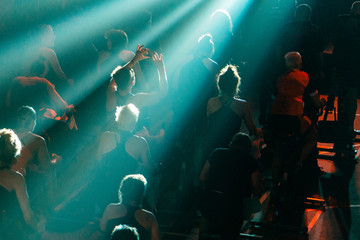 Group of people doing spinning on cycle bike, woman holding phone