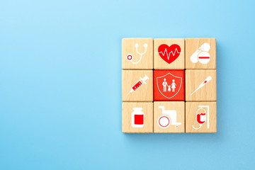 Health insurance concept, wooden blocks with healthcare medical icon, blue background, copy space