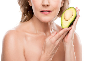 Cropped view of nude middle aged woman posing with avocado Isolated On White