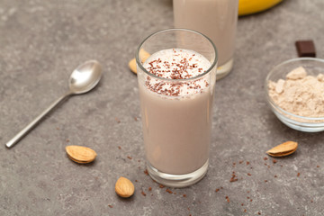 Healthy chocolate banana protein shake with almond milk in a glass. 