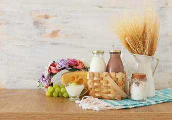 photo of dairy products over wooden table. Symbols of jewish holiday - Shavuot
