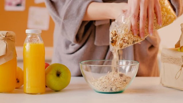 Healthy breakfast. Morning habits. Balanced nutrition. Vegan lifestyle. Woman preparing oatmeal flakes with organic fresh juice.