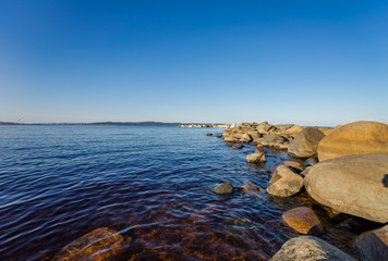 Beautiful shore of lake Onega. Petrozavodsk, Karelia. Water and stones on the shore of lake Onega.