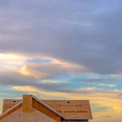 Close up of the roof of a new home viewed at a construction site at sunset