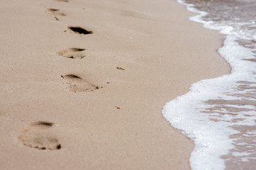 Footprints walking on the sand at the beach