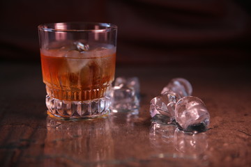 glass of whiskey with ice on black background