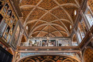 Italy, 28/03/2019: interior of San Maurizio al Monastero Maggiore, 1518 church known as the Sistine Chapel of Milan, details of the vault in the Hall of nuns with the decorated ceiling and Crucifix
