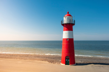 Traditional red white steel lighthouse in Westkapelle, Netherlands. © itsajoop