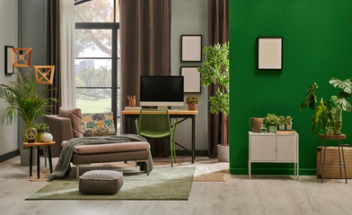 Modern living room with grey sofa and frame, green wall close up decoration in front of the window.