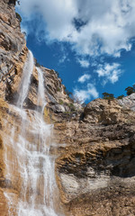 Fototapeta na wymiar Beautiful waterfall with cloudy sky landscape. Uchan su waterfall in Yalta, Crimea, Russia.