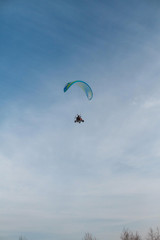 The paraglider flies over the clear blue winter sky. Free flight
