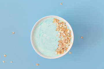 Top view healthy blue spirulina smoothie bowl with blueberry and muesli. Natural organic vegetarian food.