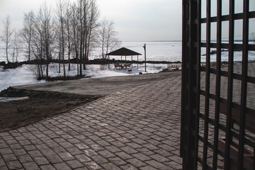 Beautiful sea view covered with ice and snow. Country rest. Park with gazebos by the sea