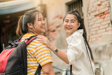 Asian woman and friend traveling to the old city in summer, She smiling and put her hand on friend shoulder.