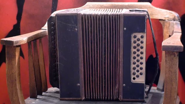 An old harmonica stands on a chair.