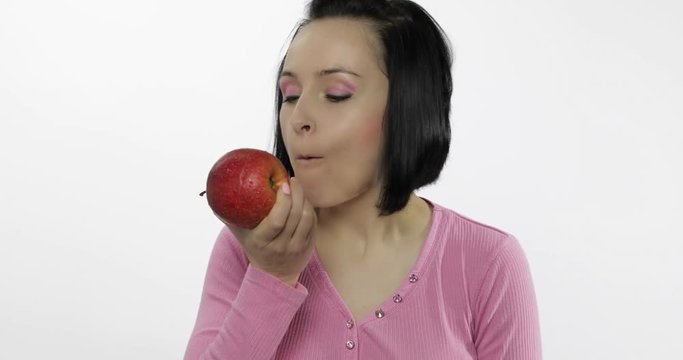 Young woman eating apple and says yum. Girl takes first bite and say wanna bite