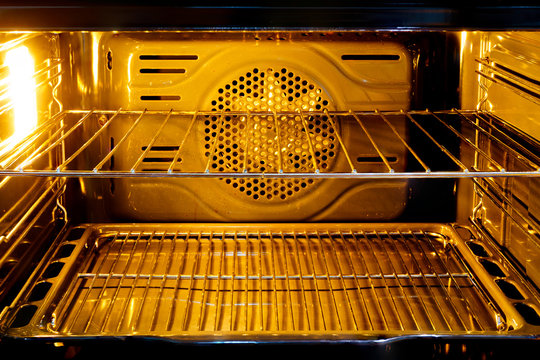 Inside the oven with orange light and a tray