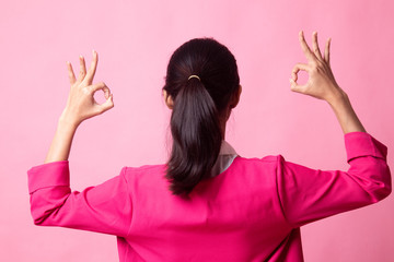 Back view of Asian woman show double OK hand sign.