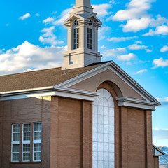 Obraz premium Clear Square Exterior of a beautiful church with a white steeple against cloudy blue sky
