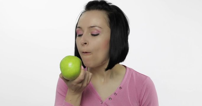 Young woman eating apple and says yum. Girl takes first bite and say wanna bite