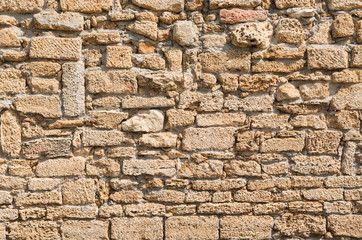Fototapeta premium Old wall laid out in a chaotic manner of porous lime brick