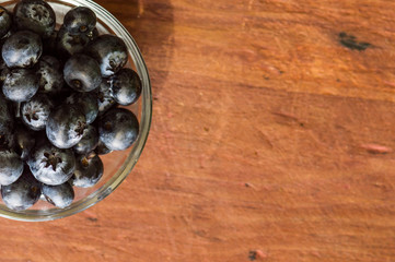 Small bowl of blueberries on wooden table