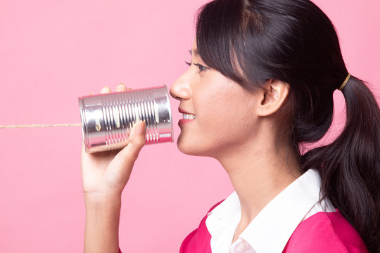 Young Asian woman with tin can phone.