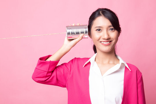 Young Asian woman with tin can phone.