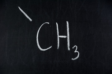 Chemical structure formula written on black chalkboard