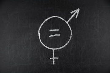 a symbol for gender equality drawn with chalk on a black chalkboard