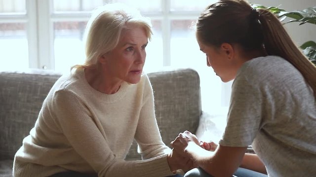 Serious old mother and young daughter talking sharing problems