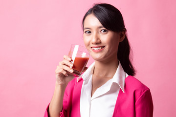 Young Asian woman drink tomato juice.