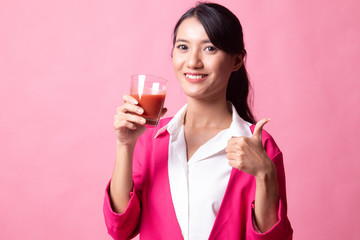 Young Asian woman thumbs up with tomato juice.