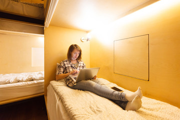 Hostel for young people. Beautiful girl student working with com